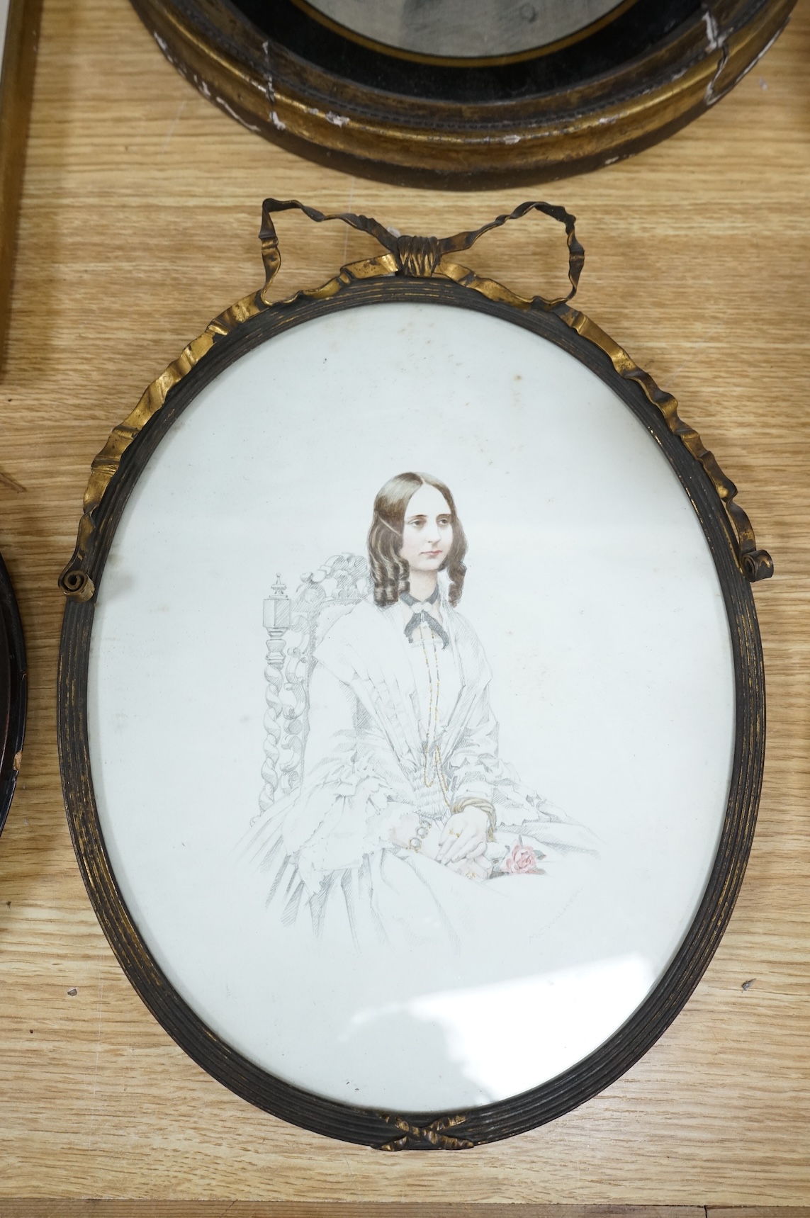 Four Regency and early Victorian portraits to include a pair of a lady and gentleman together with a carved wax bust of a lady wearing a bonnet, housed in an ebonised and gilt oval box frame, largest overall 38 x 32cm